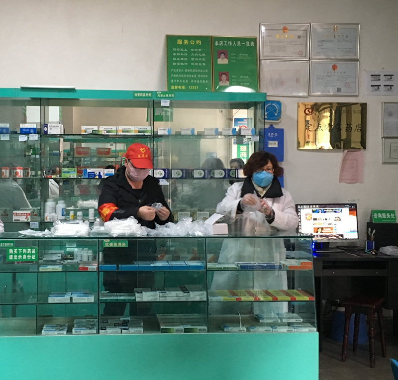 王建在药店与工作人员分装口罩 王建在药店与工作人员分装口罩